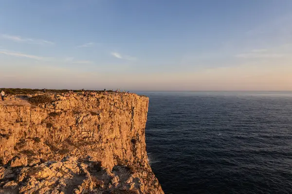stock image Landscape photo of dramatic, steep orange cliffs by the atlantic at sunset. Shot in Farol fo Cabo de Sao Vincente near Sagres, Portugal.