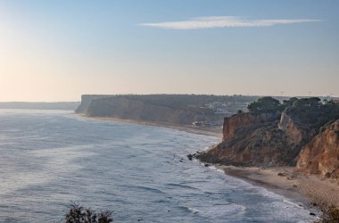 Okyanusta gün batımının sakin manzarası. Güneş ışığı suya yansıyor. Lagos, Portekiz 10 Ekim 2023.