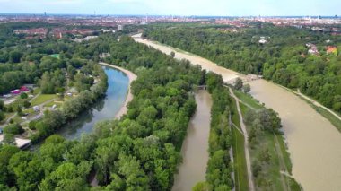 Münih 'te Bavyera Nehri' nde sel, Isar 'da hava fotoğrafçılığı. 4D İHA. Isar 'a, köprüye ve şehre yukarıdan bak. Bir eğri ile soldan sağa çapraz uçuş.