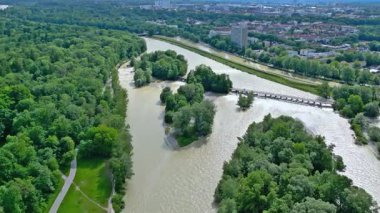 Münih Bavyera Nehri İsar 'da sel baskını, hava manzarası. 4K İHA. Isar 'a, köprüye ve şehre yukarıdan bak. Akıntı boyunca bir uçuş