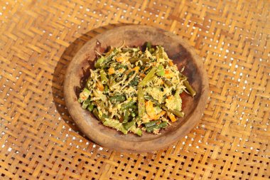 Urap Sayur Endonezya 'nın geleneksel yemeğidir. Baharatlı ve baharatlı çeşitli sebzelerle karıştırılmış bir salata tabağı. Beyaz arka planda izole edilmiş..