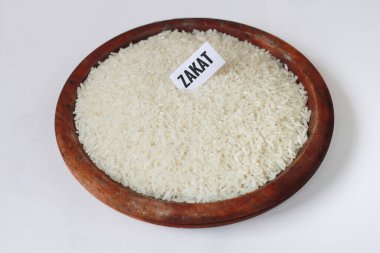 Rice in a wooden bowl on a white background.With copy space. Islamic Zakat concept.special during ramadan. clipart