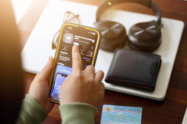 Bondowoso, Endonezya - 19 Ocak 2024: Asyalı adam Ulusal Nüfus Kimliği (IKD) başvurusuna erişiyor. Endonezya İkamet Kartı 'nın yerine mobil uygulama