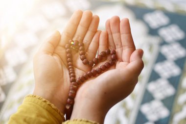 Müslüman kadının dua eden elleri pencereden gün batımına bakıyor. Ramazan kareem kavramı