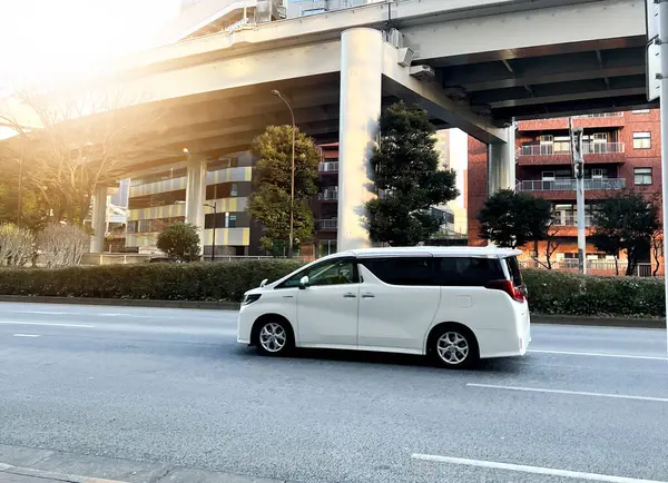 Tokyo, Japonya - 1. Januari 2023: Beyaz bir Toyota Alphard otoyoldan geçiyor.