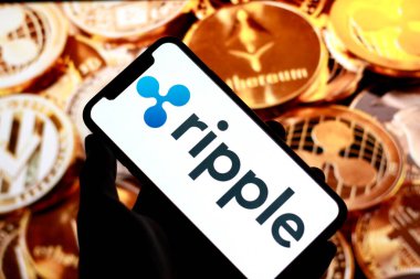 Endonezya-Nisan 25 2024: Ini bu fotoğraf dalgalı xrp logosu Finansal Teknoloji şirketi Ripple Lab, Cryptocurrency logosu akıllı telefon ekranında sergilenmektedir. Arka planda şifreli paralar.