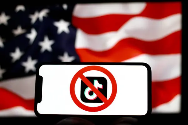 Endonezya-Nisan 25 2024: TikTok uygulamasının logosu, arka planda ABD bayrağı olan akıllı telefon ekranında gösterilen kırmızı yasaklı işaretle çizildi. TikTok 'un ABD konseptinde yasaklanması.