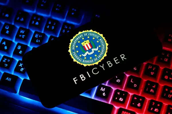 FBI Siber Soruşturma Bürosu 'nun logosu ve Amerika bayrağı. Endonezya - 29 Nisan 2024. Bilgisayar klavyesi arkaplanı