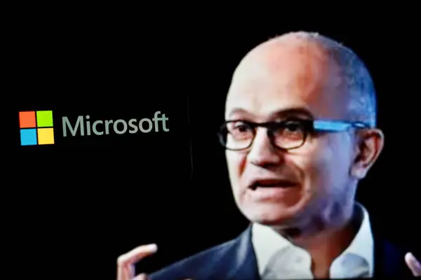 Microsoft logosu arka planda CEO Satya Nadella ile birlikte akıllı telefon ekranında gösteriliyor. Endonezya-30 Nisan 2024.