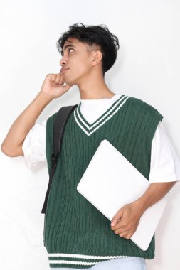 Bilgisayarlı genç Asyalı adam beyaz arka plana bakıyor. 