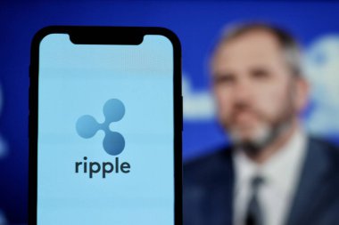 In this Photo xrp ripple Cryptocurrency logo is displayed on a smartphone screen With CEO Brad Garlinghouse in the background.indonesia-may 17th 2024. clipart