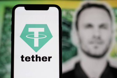 In this Photo tether Cryptocurrency logo is displayed on a smartphone screen With CEO Paolo Ardoino in the background.indonesia-may 17th 2024. clipart