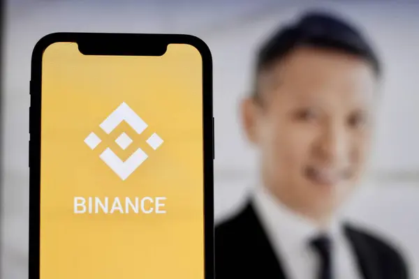 stock image In this Photo Binance Cryptocurrency logo is displayed on a smartphone screen With CEO Richard Teng in the background.indonesia-may 17th 2024.