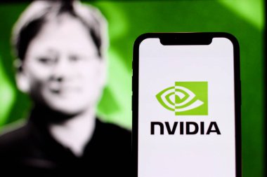 Bu resimde NVIDIA logosu arka planda CEO Jensen Huang ile birlikte akıllı bir telefonda sergilenmektedir. Endonezya - 20 Mayıs 2024.