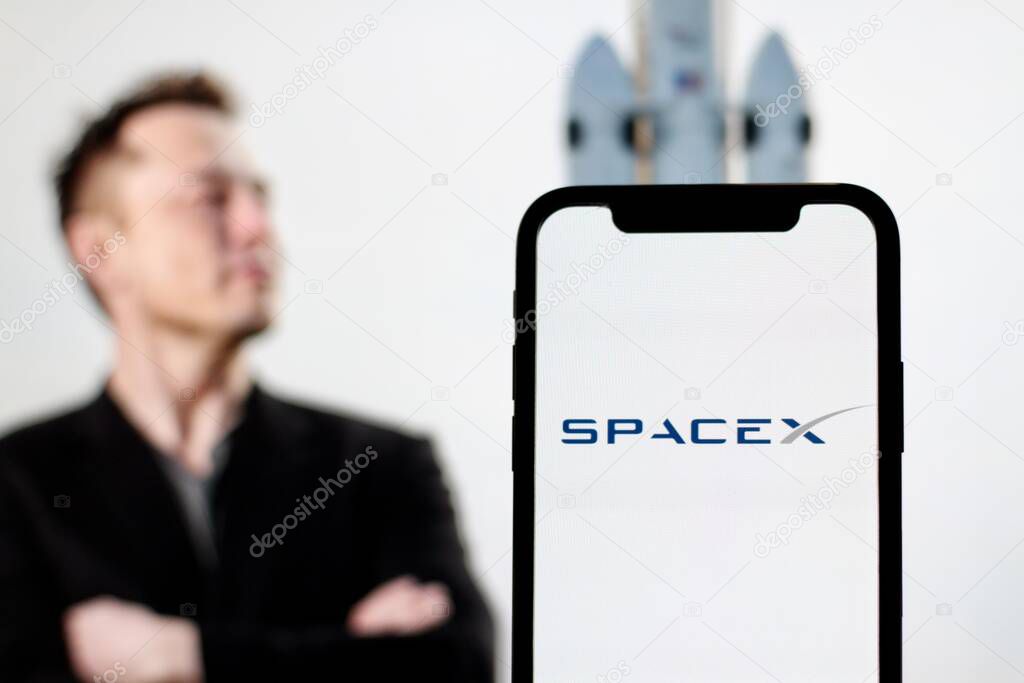 In this Photo The Starlink logo is displayed on smartphone screen With CEO Elon Musk in the background