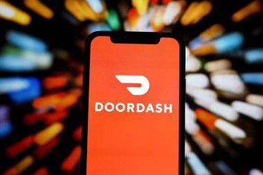 INDONEZYA - 1 Haziran 2024: Bu resimde, çevrimiçi bir gıda dağıtım şirketi olan Doordash 'ın logosuna sahip bir kişi akıllı telefon ekranında sergileniyor.