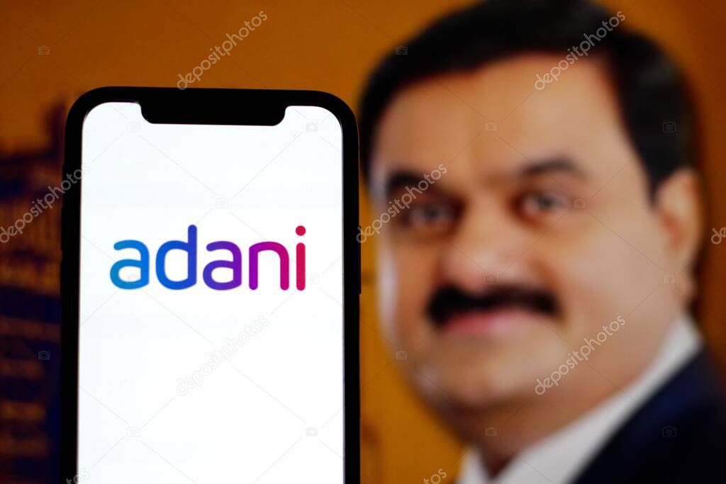 INDONESIA - JUNE 4TH, 2024: In this photo illustration,the logo of Adani group is displayed on a smartphone screen with CEO Gautam Adani in the background