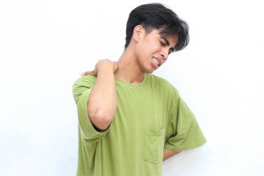 Yeşil gömlekli genç adam belini tutarken acı içinde kıvranıyor. Rahatsızlık ya da gerginlik hissediyor gibi görünüyor.