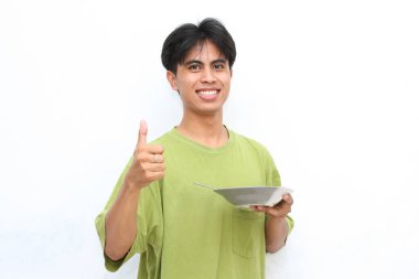 Yeşil gömlekli genç adam hevesle bir tabak erişte yedi, baş parmağını kaldırdı, bu da lezzetli olduğu anlamına geliyordu..