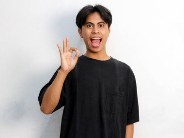 Siyah tişört giyen Asyalı bir gencin beyaz bir arka planda izole edilmiş komik bir portresi..