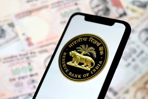 logo of Reserve Bank of India,TheRBI, is displayed on asmartphone screen with indian money in the background.indonesia - June 10th 2024.