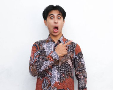 Vay be portresi ve izole edilmiş beyaz arka plandaki boş alanı gösteren batik tişört giyen Endonezyalı adamın şaşırmış yüzü..