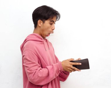 Tuhaf bir suratı olan, elinde boş bir cüzdan olan, beyaz bir arka planda izole edilmiş pembe kapüşonlu, zavallı bir Asyalı gencin portresi..