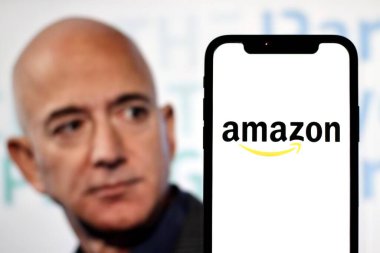 Bu resimde Amazon logosu, kurucusu Jeff Bezos ile birlikte arka planda bir akıllı telefonda sergilenmektedir. Endonezya - 23 Haziran 2024.