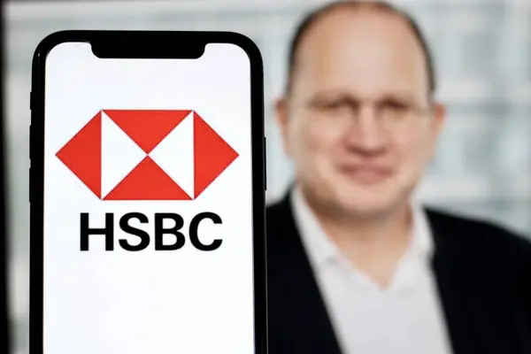 stock image In this photo illustration,the logo of HSBC,is displayed on a smartphone with CEO Mark Tucker in the background.indonesia - June 27th 2024.