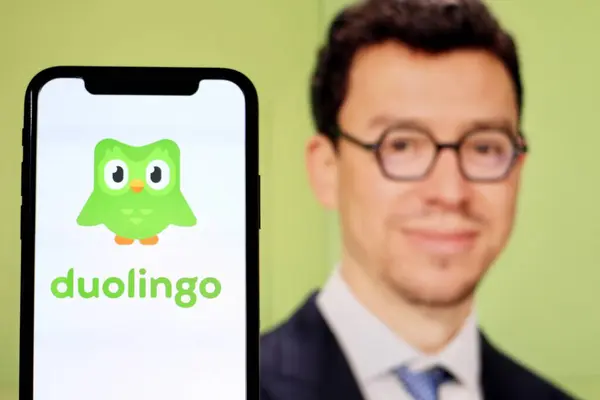 stock image In this photo illustration,the logo of Duolingo,with CEO Luis von Ahn in the background.indonesia - June 27th 2024.