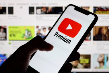 Telefon ekranında youtube uygulama simgesiyle el ele tutuşmak