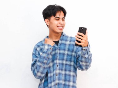 Stüdyoda akıllı telefonla poz veren Asyalı genç adam.