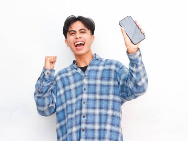 Stüdyoda akıllı telefonla poz veren Asyalı genç adam.