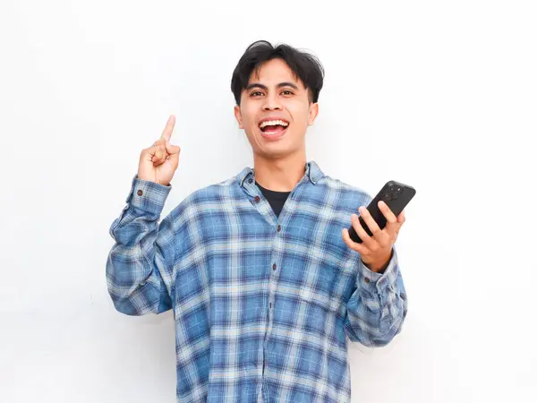 stock image young asian man posing with smartphone in studio