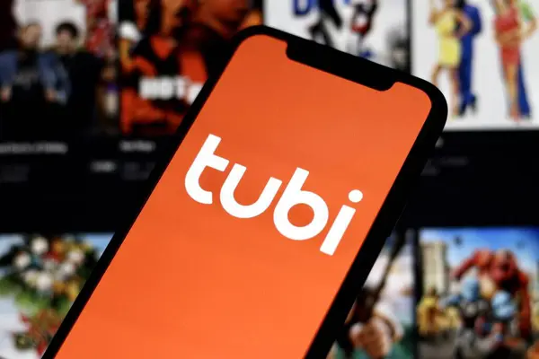 Tubi logosuna sahip akıllı telefonun yakın görüntüsü, Amerikan içerik platformu ve Fox Corporation 'a ait reklam destekli yayın servisi.