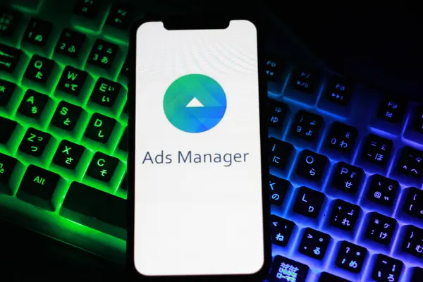 stock image close up view of the smartphone on neon keyboard with Ads Manager logo