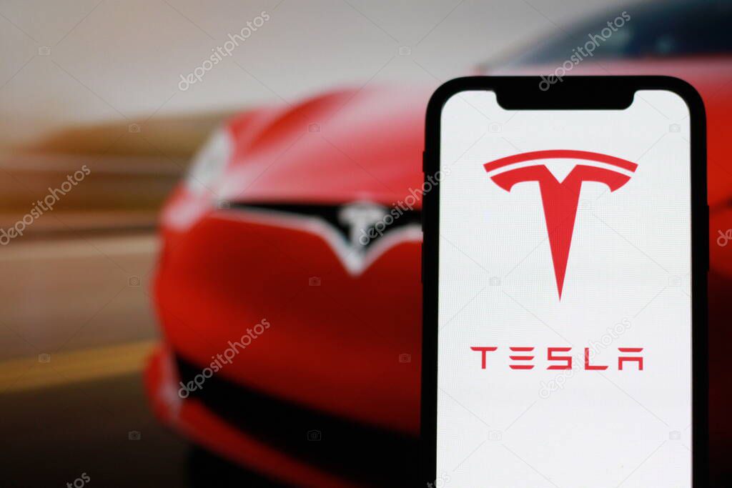 Close up view of modern smartphone screen with tesla logo
