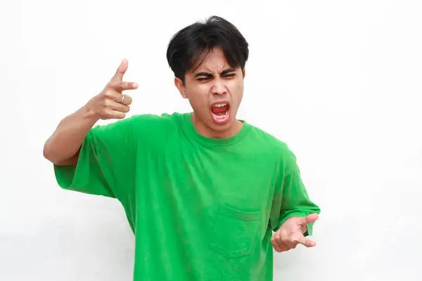 Stock image Adult Asian man wearing green t-shirt posing with angry gesture with punching hand gesture on white background.