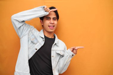 Vay canına, genç Asyalı adam açık alanı gösteriyor mutlu, heyecanlı Asyalı genç adam sarı arka planda izole edilmiş açık alanı gösteriyor, reklam ihtiyaçları için mükemmel..