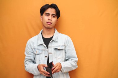 Zavallı Asyalı adam boş cüzdan tutuyordu. Asyalı adam boş cüzdan tutuyordu. Yan tarafa bakıyordu..