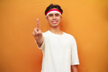 Mutlu bir Endonezyalı, sarı arka planda parmaklarıyla birden beşe kadar sayarak poz verir. Endonezya 'nın 17 Ağustos' taki bağımsızlık gününü kutlama konsepti.