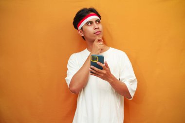 Endonezyalı adam Endonezya 'nın bağımsızlık gününü kutlamak için elinde cep telefonu tutuyor. 17 Ağustos' ta, el pençe divan, kafa karıştırıcı bir fikir.