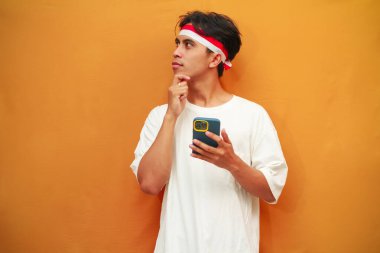 Endonezyalı adam Endonezya 'nın bağımsızlık gününü kutlamak için elinde cep telefonu tutuyor. 17 Ağustos' ta, el pençe divan, kafa karıştırıcı bir fikir.