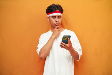 Endonezyalı adam Endonezya 'nın bağımsızlık gününü kutlamak için elinde cep telefonu tutuyor. 17 Ağustos' ta, el pençe divan, kafa karıştırıcı bir fikir.