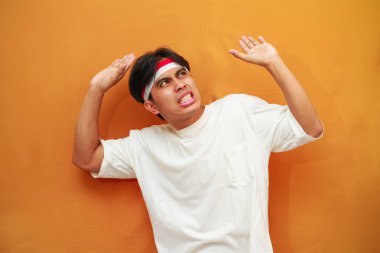 Endonezyalı erkekler 17 Ağustos 'ta Endonezya Bağımsızlık Günü' nü kutladılar. Başında bir şey taşıyorlar. Sarı arka planda izole edilmiş fotokopi alanı..