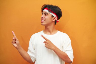 Endonezya 'nın 17 Ağustos' taki bağımsızlık gününü kutlayan mutlu Endonezyalı adam, Endonezya 'nın bağımsızlık gününü kutlarken parmağını gösterdi.