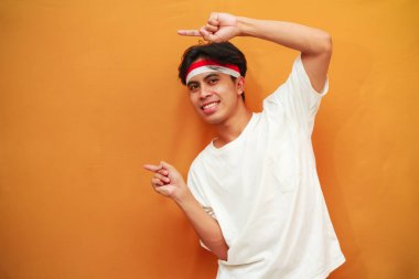 Endonezya 'nın 17 Ağustos' taki bağımsızlık gününü kutlayan mutlu Endonezyalı adam, Endonezya 'nın bağımsızlık gününü kutlarken parmağını gösterdi.