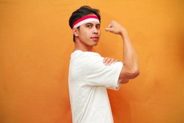 Gülümseyen Endonezyalı erkekler 17 Ağustos 'ta Endonezya' nın Bağımsızlık Günü 'nü kutladılar. Endonezyalı erkeklerin kendinden emin yüzleri direnişin ve gücün sembolü olan kaslarını kaldırma ve gösterme pozu verdiler..