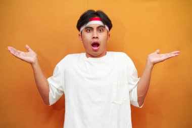 Endonezyalı adam Endonezya 'nın bağımsızlık gününü 17 Ağustos' ta kutluyor, iki elini de kaldırıyor ve kafası karışık bir yüz ifadesi sergiliyor.