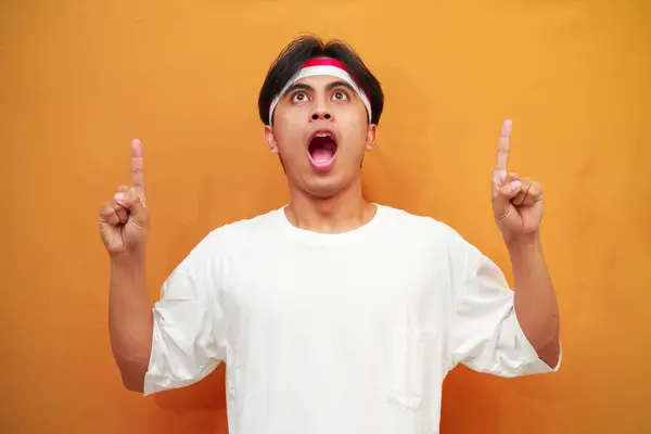 Stock image happy Indonesian man celebrating Indonesian independence day on August 17th, wow excited face Indonesian man celebrating Indonesian independence day while pointing with his finger